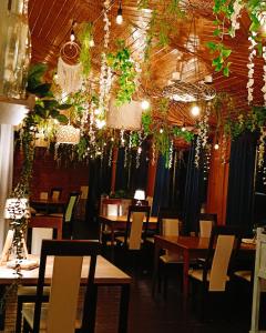 a restaurant with tables and chairs and hanging plants at Pokoje gościnne Restauracja u Kusia in Mikołów