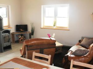 sala de estar con muebles de cuero y 2 ventanas en Modern Holiday Home in Brusow with Roofed Terrace, en Kröpelin