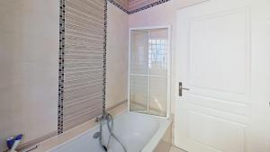 a bathroom with a bath tub and a window at EXIGEHOME - Maison à 2 pas de la foret - 10 min de Versailles in Vélizy-Villacoublay