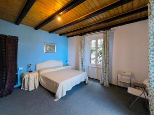 een slaapkamer met een bed met blauwe muren en een raam bij Apartment Buenavista in Stresa