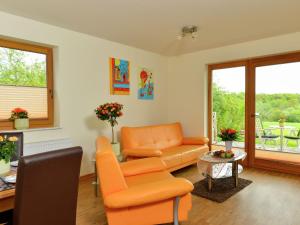 a living room with an orange couch and a chair at Lovely Apartment in M rz with Garden Balcony in Lahr