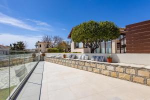 un patio con una pared de piedra con almohadas en Villa Pacy, en Ayios Theodhoros