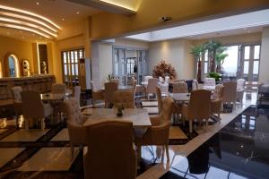 een eetkamer met tafels, stoelen en ramen bij The Grantage Hotel & Sky Lounge in Serpong
