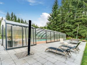 une maison en verre avec deux chaises et une table dans l'établissement Luxurious Apartment in J gersgr n with Saunas, à Jägersgrün