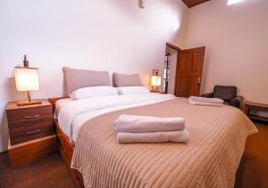 um quarto com uma cama grande com duas toalhas em Lauriston Villa Ooty by VOYE HOMES em Ooty