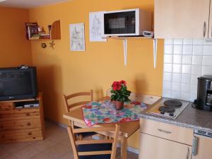 cocina con mesa pequeña y cocina con TV en Comfortable Apartment near Seabeach in Rerik, en Rerik