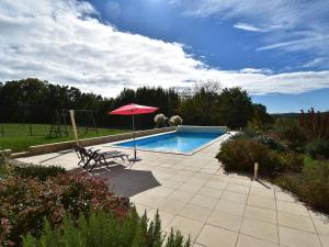 uma piscina com um guarda-sol e uma cadeira e uma mesa e um guarda-sol em Holiday home in Montcl ra with sunny garden playground equipment and private pool em Montcléra