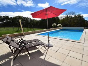 een rode parasol en een stoel naast een zwembad bij Holiday home in Montcl ra with sunny garden playground equipment and private pool in Montcléra