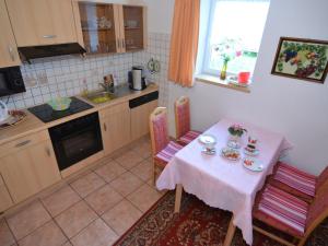 a kitchen with a table and chairs and a table and a sink at Holiday Home in Neustadt am Rennsteig with Pond in Neustadt am Rennsteig
