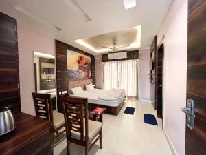 a bedroom with a bed and a table and chairs at Hotel R R . Puri fully-air-conditioned-hotel near-sea-beach-&-temple with-lift-And restaurant-availability in Puri