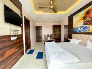a bedroom with a bed and a flat screen tv at Hotel R R . Puri fully-air-conditioned-hotel near-sea-beach-&-temple with-lift-And restaurant-availability in Puri