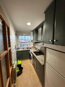 a kitchen with green cabinets and a stainless steel refrigerator at Bonito piso a solo 15 minutos de Granada in La Zubia
