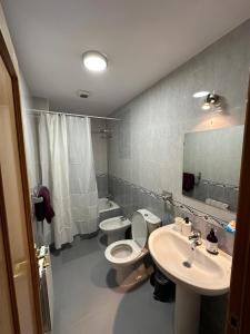 a bathroom with a toilet and a sink and a mirror at Bonito piso a solo 15 minutos de Granada in La Zubia