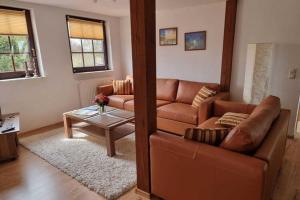 ein Wohnzimmer mit einem Sofa und einem Tisch in der Unterkunft Beautiful Apartment in Robertsdorf with Garden in Blowatz