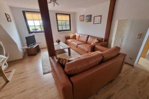 ein Wohnzimmer mit einem braunen Sofa und einem Tisch in der Unterkunft Beautiful Apartment in Robertsdorf with Garden in Blowatz