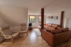 ein Wohnzimmer mit einem Sofa und 2 Stühlen in der Unterkunft Beautiful Apartment in Robertsdorf with Garden in Blowatz