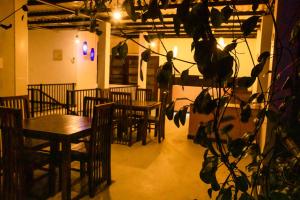 a restaurant with wooden tables and chairs and a plant at Sharta Yala in Tissamaharama