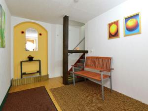 a living room with a chair and a staircase at Cozy Apartment in L wensen Lower Saxony with Private Terrace in Bad Pyrmont