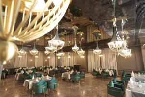 a dining room with tables and chairs and chandeliers at Classic Sapphire Ananta Bundi in Būndi