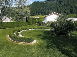 un jardin avec une courbe en herbe dans l'établissement Fewo Birkenhof, à Langen bei Bregenz