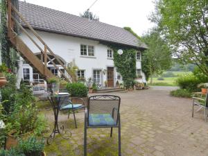 een tafel en stoelen voor een wit huis bij Cozy Apartment in Immerath with Fishing Near in Immerath