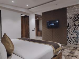 a bedroom with a bed and a tv on a wall at Classic Sapphire Ananta Bundi in Būndi