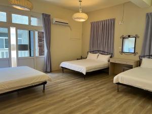 Zimmer mit 2 Betten und einem Spiegel in der Unterkunft 珊瑚礁民宿 in Magong