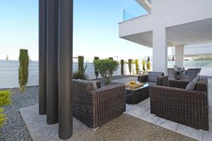 - une terrasse avec des chaises en osier et une table dans un bâtiment dans l'établissement Villa Theresa, à Protaras