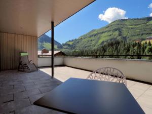 ダーミュルスにあるAparthotel Alpinresort Damülsの山の景色を望むバルコニー(テーブル、椅子付)