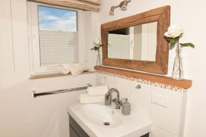 a bathroom with a sink and a mirror at Jagahäusel Appartement Gitti in Jochberg