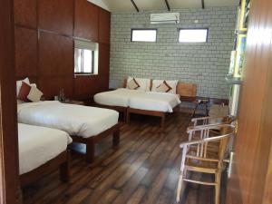 a room with three beds and a ladder in it at Discovery Village Resorts in Begūr