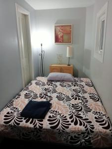 薩里的住宿－Small Cozy Private Room For 1 or 2 Travellers in a Great Location (King George Boulevard, Surrey)，一间卧室配有一张带黑白毯子的床