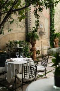 マドリードにあるRelais & Châteaux Hotel Orfilaのワイングラス付きのテーブルと椅子