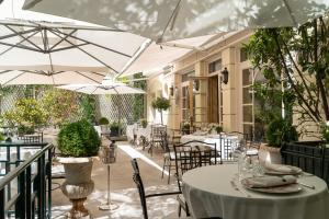 a patio with tables and chairs and umbrellas at Relais & Châteaux Hotel Orfila in Madrid