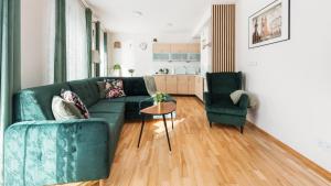 - un salon avec un canapé vert et 2 chaises dans l'établissement Apartamenty Sun & Snow Angel City, à Cracovie
