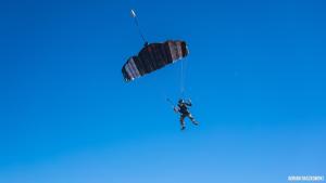 Un homme est suspendu à un parachute dans le ciel dans l'établissement Apartamentos Bollullos, à Bollullos de la Mitación