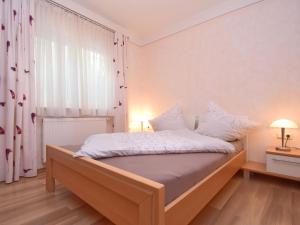 德根多夫的住宿－Lovely flat in Deggendorf with luxurious furnishings with southern flair，一间卧室配有一张带白色床单的大床