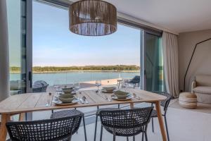 a dining room with a table and chairs and a large window at Blu Mare Hotel in Novigrad Istria