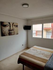 1 dormitorio con 1 cama y una foto de máscara en HOLIDAY CENTRE DELUXE, en Alicante