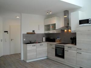 a kitchen with white cabinets and a stove top oven at Holiday home on the island of Poel 3 bedrooms 2 bathrooms sauna in Insel Poel