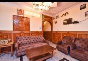 een woonkamer met een bank en een tafel bij Hotel Avalanche in Shimla