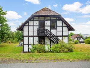 a small house with a black and white exterior at Spacious Apartment in Frankenau Hesse near the Forest in Frankenau
