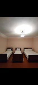 a room with two beds and a light on the ceiling at MD Guest House in Getahovit
