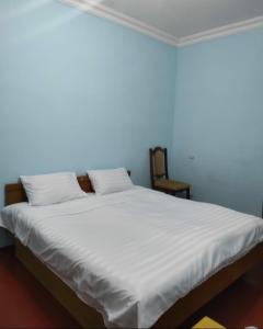 a bedroom with a large bed with white sheets at MD Guest House in Getahovit