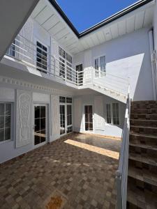 Dieses weiße Haus verfügt über eine Terrasse und einen Balkon. in der Unterkunft Boulevard Architectural Hotel Wifi 100 MBS in Buxoro