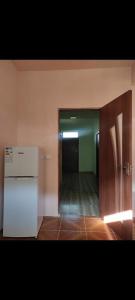an empty room with a refrigerator and a hallway at MD Guest House in Getahovit