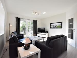 Sala de estar con 2 sillas negras y mesa en Charming Apartment in Oldenburg in Holstein with Terrace, en Oldenburg in Holstein