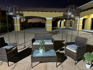 un patio con 3 sillas y una mesa con una planta en Ein Gedi Premier Lodge en Kimberley