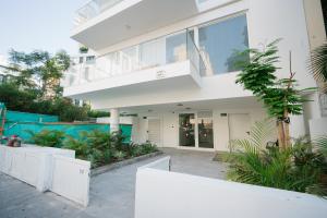 une maison blanche avec un balcon et des plantes dans l'établissement Lapin Luxury Apartment By Nimizz, à Tel Aviv