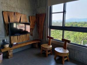a room with two chairs and a tv and windows at 玉井-望明79 in Yujing